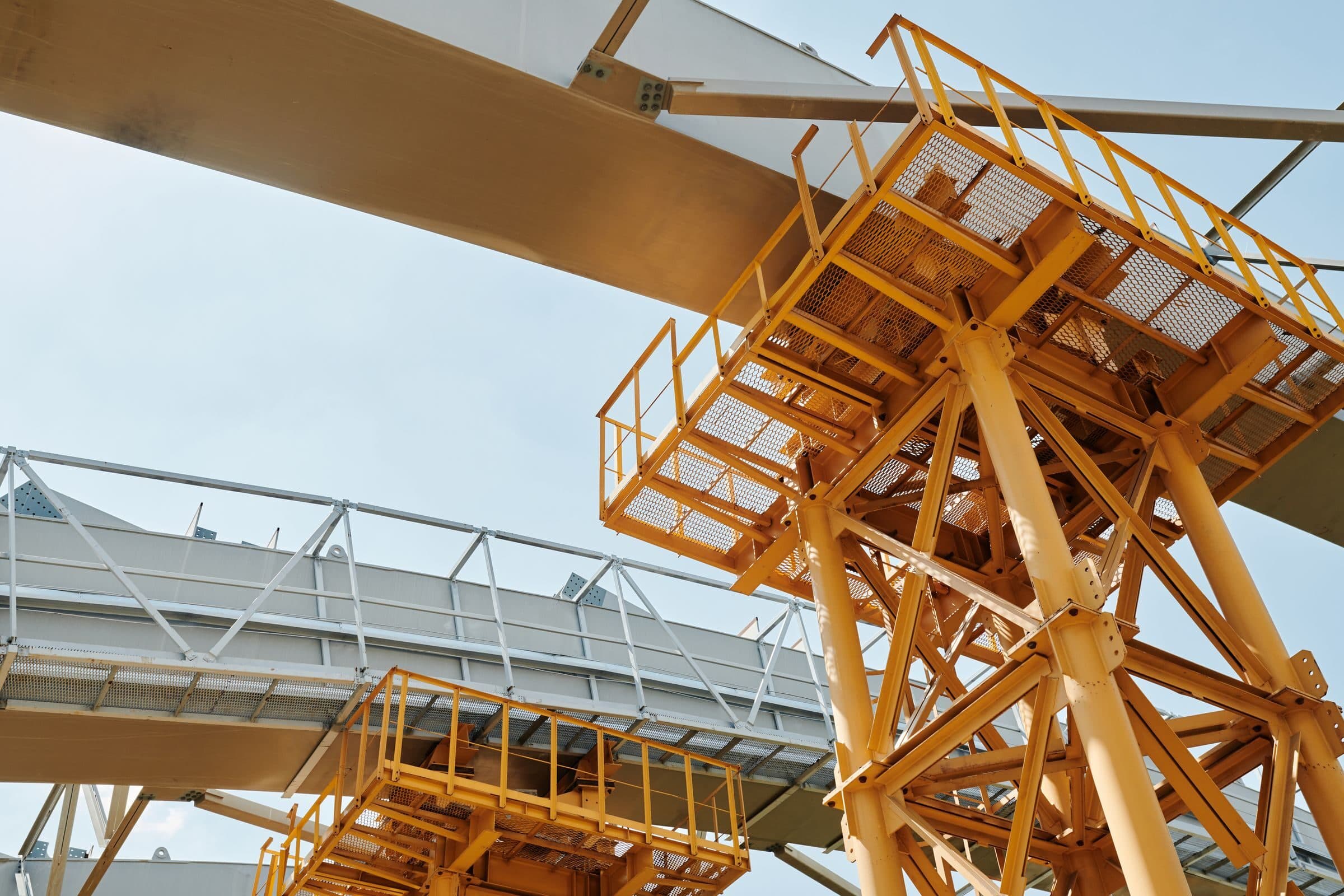 Yellow steel framing and walkways on a construction site, a project builders risk insurance covers until it is finished