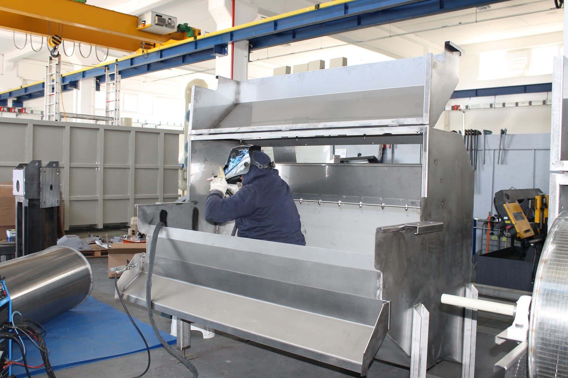 Un soldador fabrica equipo de acero en un taller, un riesgo difícil de colocar que suele asegurarse en el mercado de excedentes