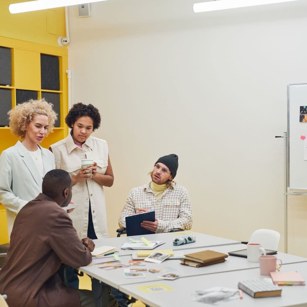Compañeros de trabajo reunidos en una mesa de oficina