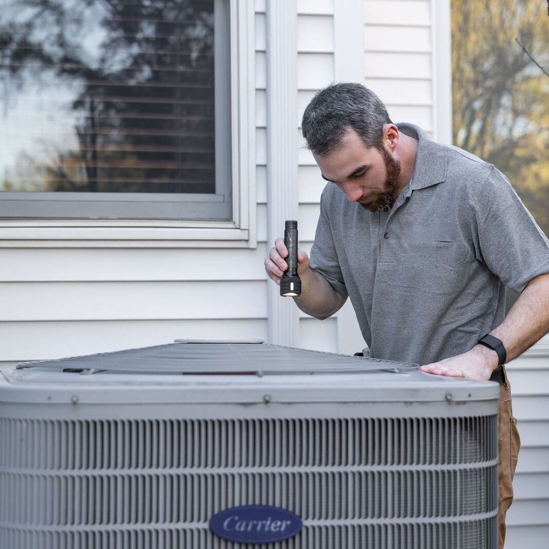 A technician inspecting an air conditioning unit