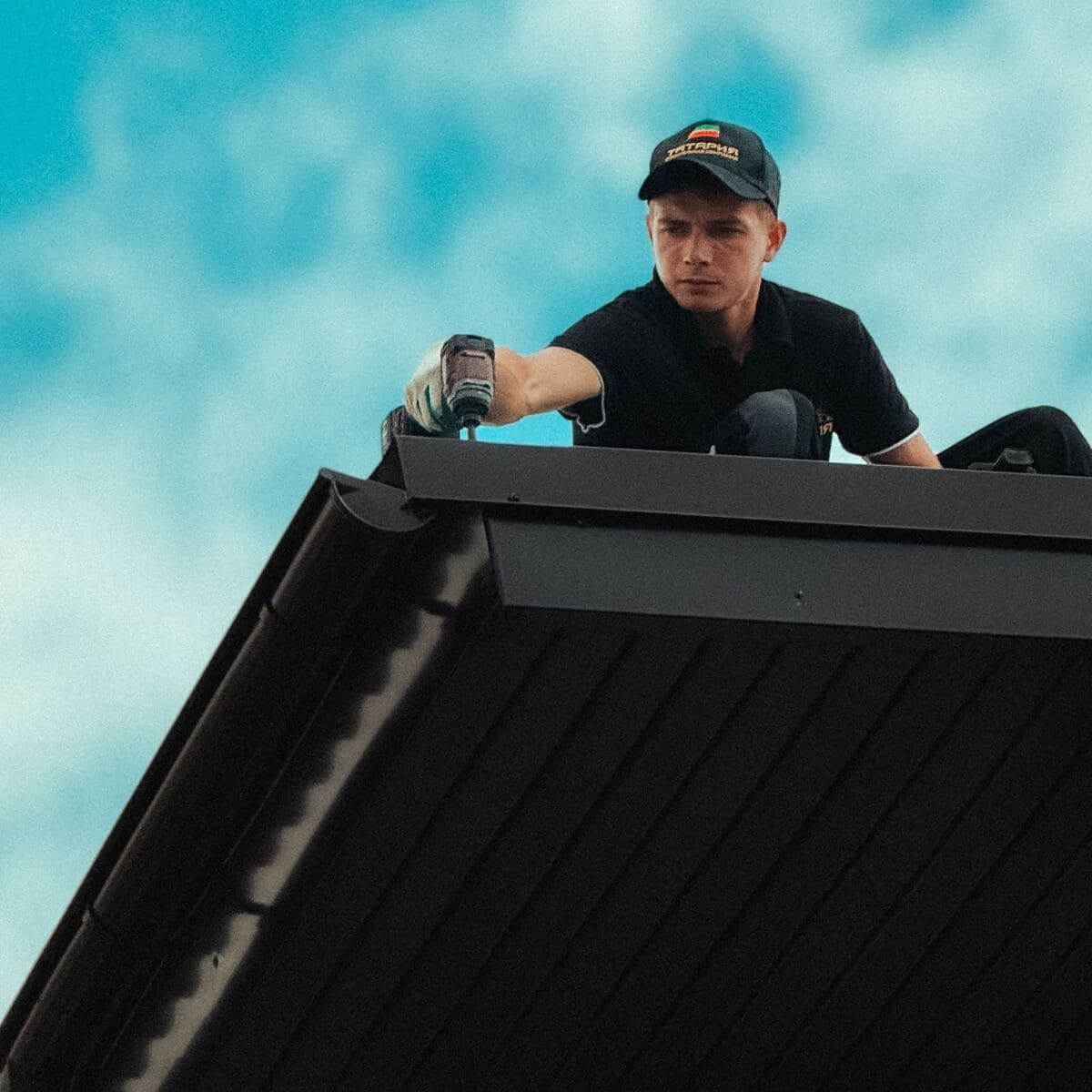 A roofer working on the edge of a house roof
