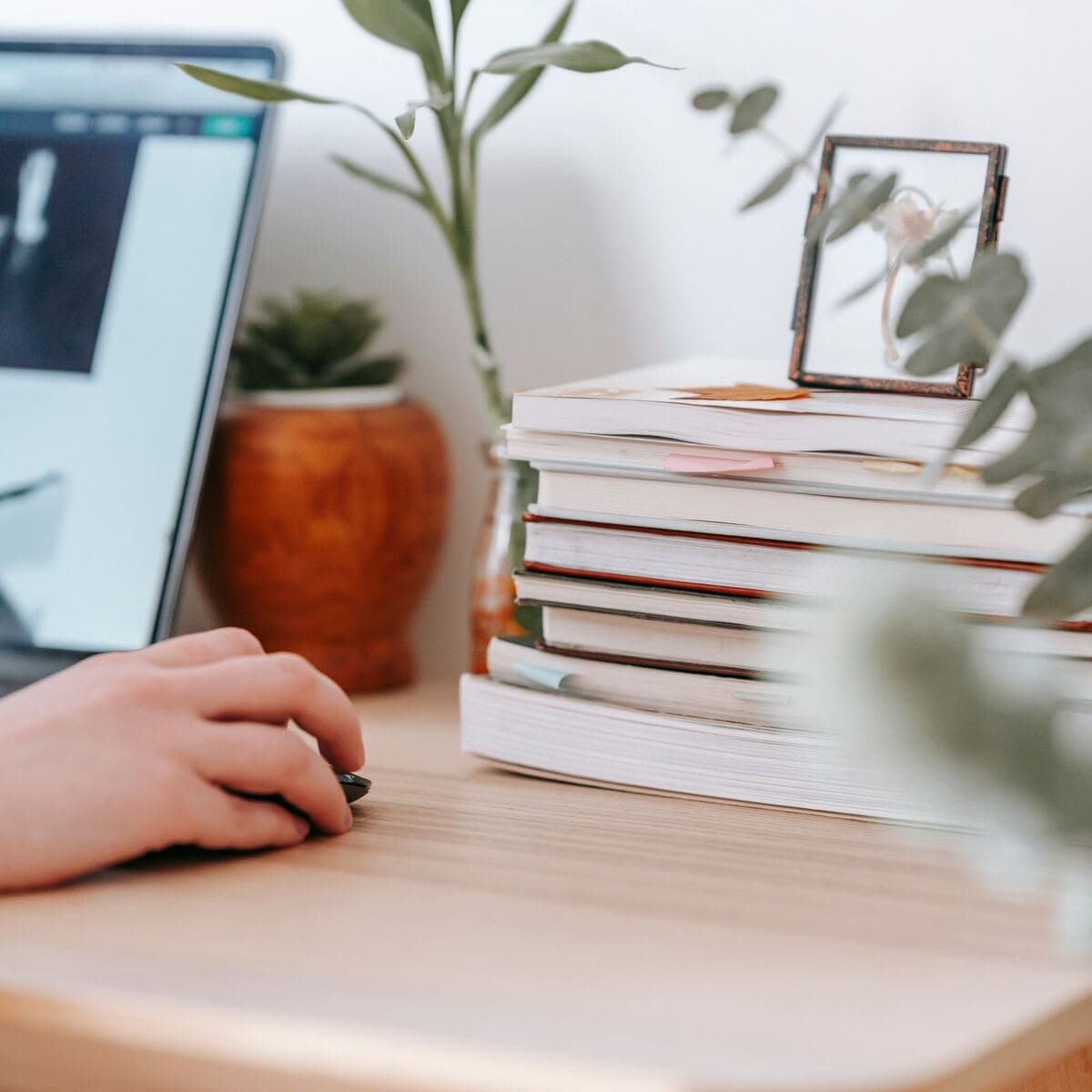 A home office desk with a laptop and books