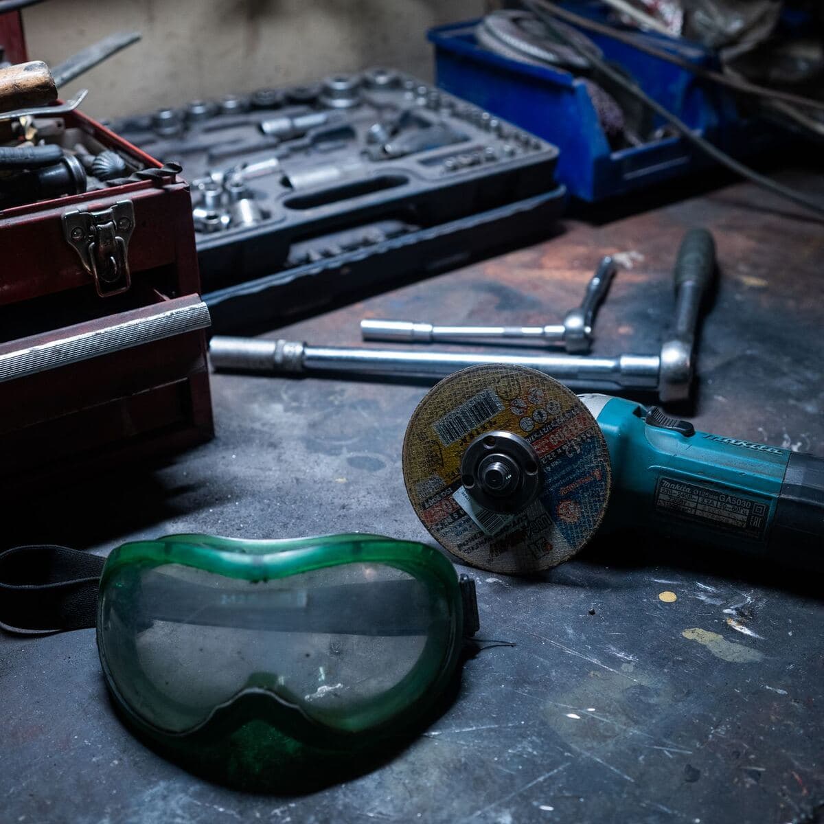 Herramientas eléctricas y gafas de seguridad sobre un banco de trabajo