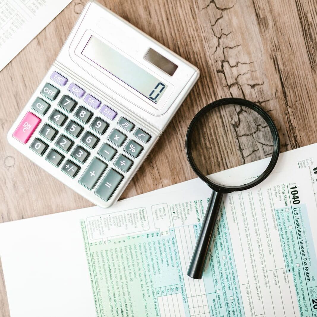 Formularios de impuestos con una calculadora y una lupa